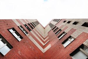 Red striped bricks Russian house. Similar letter M skyscraper. R photo
