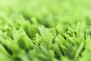 Green artificial grass texture with blurred background. Modern s photo