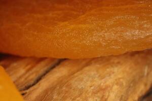 Dried Apricot on Wood Texture. Warm Nature Organic Background. Macro Closeup. photo