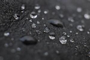 Elegant water drops on black leather background texture. Macro Closeup. photo