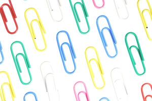 Many Colored Isolated Paper Clips Pattern. Office Stationery Equipment Background. photo