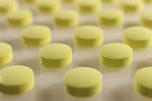 Yellow Isolated Pills Texture. Medical Tablets Background. Macro Closeup. photo