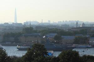 Russian Navy Battleship Soobrazitelniy on Neva River. Saint-Petersburg roofs cityscape scenery with massive buildings on horizon. photo