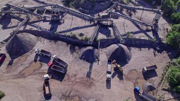 Excavator loading crushed stone into a dump truck in a crushed stone quarry video