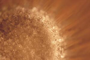 Sugar at the bottom of a faceted glass. Macro closeup artwork. photo