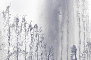 Fountain water streams dynamic motion. Wet spray summer waterfall. photo