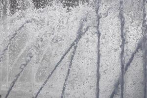 Fountain water streams dynamic motion. Wet spray summer waterfall. photo