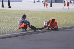 Two workers sit on the road and repair it photo