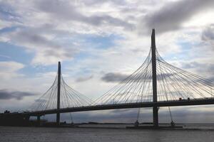 Massive cable-stayed bridge construction above Neva river. Clouds in the sky. photo