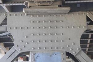Powerful metal construction with rivets. Part of the bridge. photo