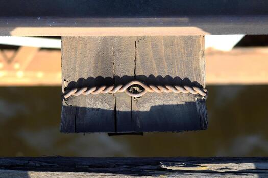 Rusty wire twisted around a wooden block. photo