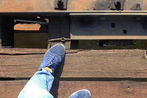 Men's feet on the railway bridge photo