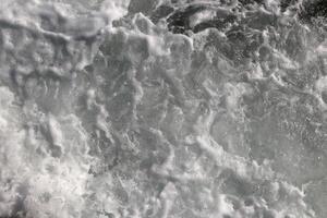 Outdoor water froth swirls backdrop. Sea wave foam texture. Marine aqua motion surface background. photo