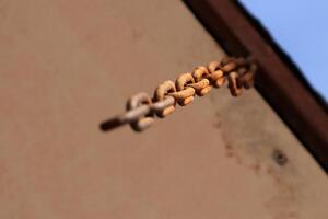 Rusty chain hanging from above. Macro closeup. photo