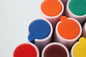 Pen markers multicolor caps macro closeup. Back to school composition. Colored market caps background. photo