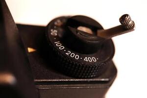 Old photo camera exposure control knob background. Macro closeup.