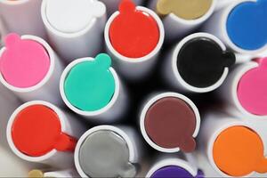 Pen markers multicolor caps macro closeup. Back to school composition. Colored market caps background. photo
