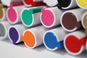 Pen markers multicolor caps macro closeup. Back to school composition. Colored market caps background. photo