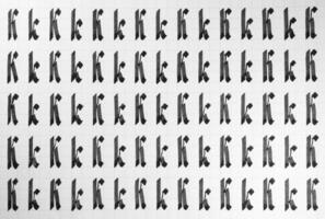 Calligraphy black and white letters K background. Lettering practice writing worksheet. Handwriting symbol filling pattern. Calligraphic letter k learning skills paper page. photo