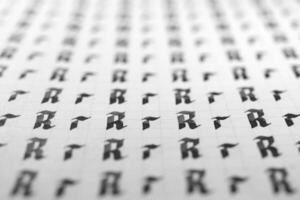 Calligraphy black and white letters R background. Lettering practice writing worksheet. Handwriting symbol filling pattern. Calligraphic letter r learning skills paper page. photo