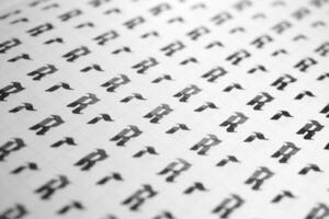 Handwriting black and white symbol filling pattern. Calligraphic letter R learning skills paper page. Calligraphy letters r background. Lettering practice writing worksheet. photo