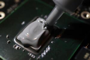 Applying thermal paste to the processor microchip. photo