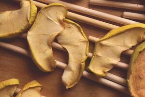 Apple slices are dried on wood sticks. Macro closeup. photo