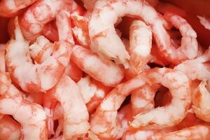 Boiled peeled shrimps meat texture. Prawns snack filling background. photo