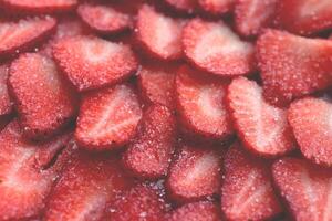 Sliced strawberry in sugar filling background. Red healthy tasty strawberry with sugar texture. Fresh vitamin berry backdrop. photo