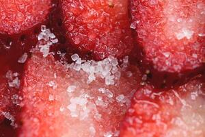 Sliced strawberry in sugar filling background. Red healthy tasty strawberry with sugar texture. Fresh vitamin berry backdrop. photo