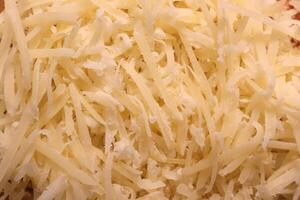 Parmesan filling texture. Grated cheese background. photo