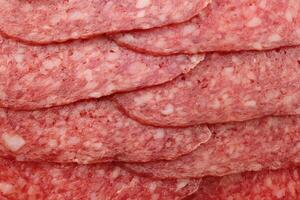Sausage slices filling background. Salami snack slices texture. photo