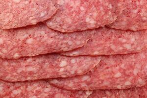 Sausage slices filling background. Salami snack slices texture. photo