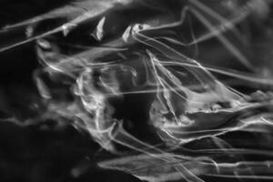 Drawing of the glowing rays of the sun on crumpled cellophane. Black and white. Filling background. photo