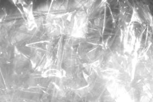 Crumpled cellophane texture. Plastic light reflection filling background. photo