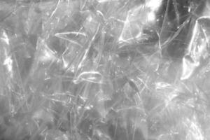 Crumpled cellophane texture. Plastic light reflection filling background. photo