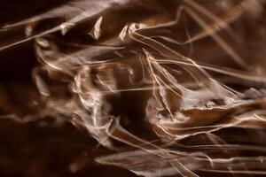 Drawing of the glowing rays of the sun on crumpled cellophane. Filling background. photo