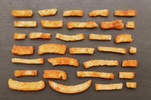 Fried crackers rows on black stone background photo