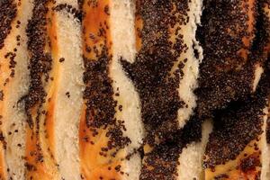 Sweet fresh poppy roll bun slices. Macro closeup. Filling background. photo