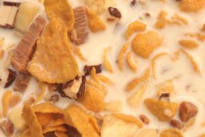 Cornflakes with chocolate sliced banana and milk. Filling background. Macro close-up. photo