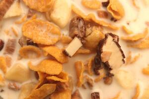 Cornflakes with chocolate sliced banana and milk. Filling background. Macro close-up. photo