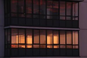 Residential building balcony with orange sky windows reflection photo