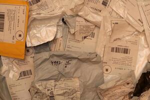 Many post packets and one yellow with labels filling background. photo