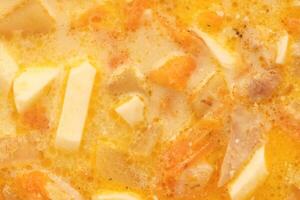 Chicken cream soup with eggs filled background. Yellow tasty meat bouillon texture. Health orange broth surface. Dinner home food. photo