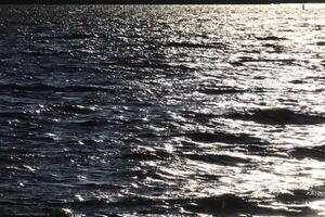The surface of the Gulf of Finland with the rays of the sun on the surface and a horizon line photo