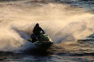 Active and energetic riding on a jet ski. Lots of splashes. Sports action. photo