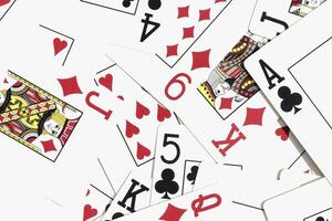 Assorted play cards backdrop. Many miscellaneous jumbled playing cards surface. Mixed playing cards background. photo