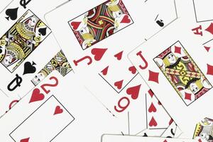Assorted play cards backdrop. Many miscellaneous jumbled playing cards surface. Mixed playing cards background. photo