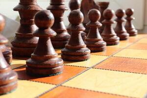 Black figures row. Chess figures background. Wood game chessboard. photo