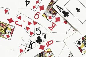 Many miscellaneous jumbled playing cards surface. Mixed playing cards background. Assorted play cards backdrop. photo